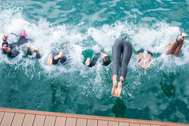 Swimmers diving into water