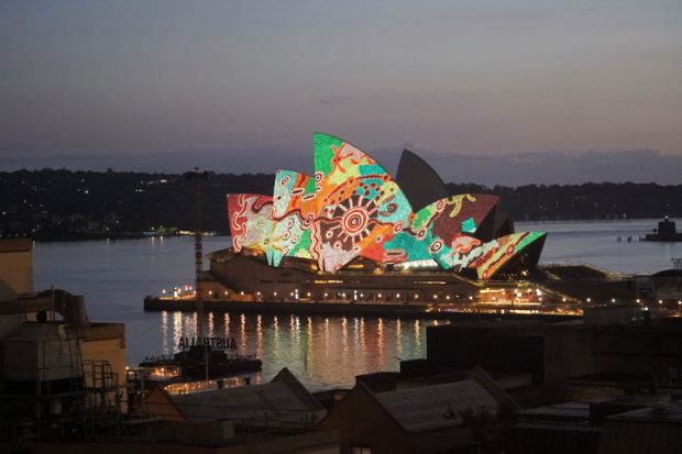 The sails of the Sydney Opera House lit up with an aboriginal design