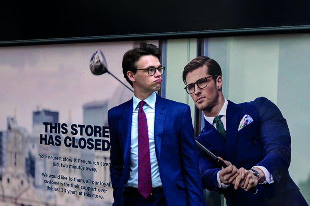 A businessman pauses next to a closed shop poster featuring a similar man also wearing a blue suit and enjoying leisure time on the golf course