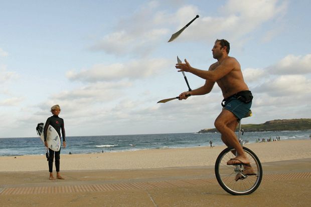 Juggler on a unicycle near surfer