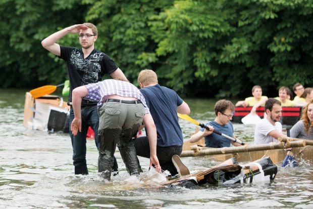 Cambridge University Students Cardboard Boat Race. A good captain never abandons his boat even as she goes down
