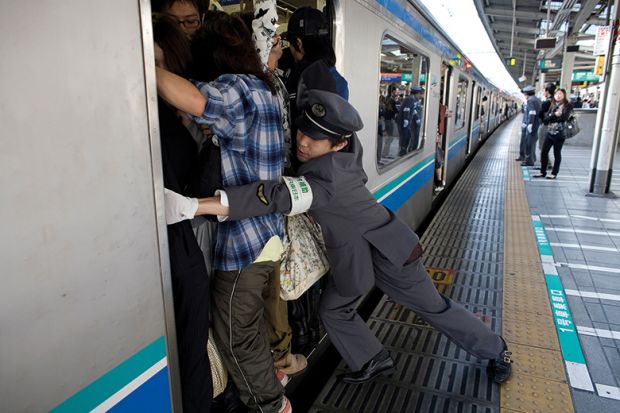 People cram on to a train in Japan