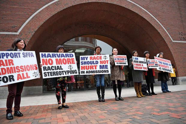 Demonstrators hold slogans in front of John Joseph Moakley United States Courthouse in Boston, Massachusetts