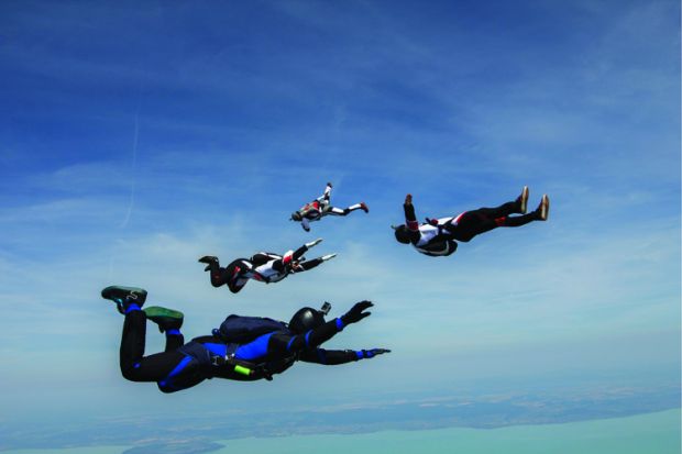 Four young adult male skydivers free falling