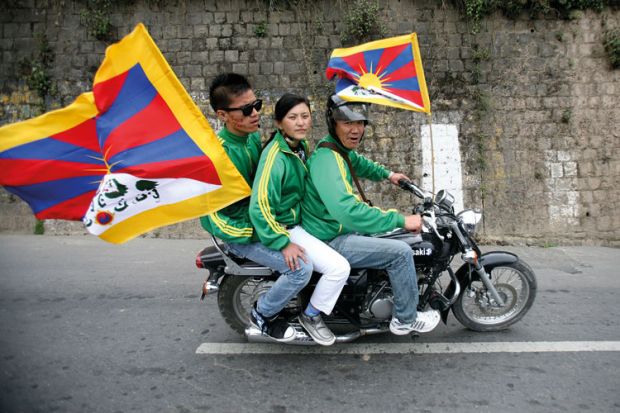 Exiled Tibetan protesters riding on motorbike