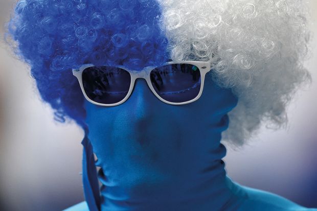 Person wearing morph suit and curly wig in Finland flag colours
