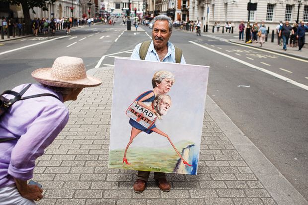 A woman looks at a painting by political artist Kaya Mar on Whitehall ahead of the pro-EU 'March for a People's Vote' in London