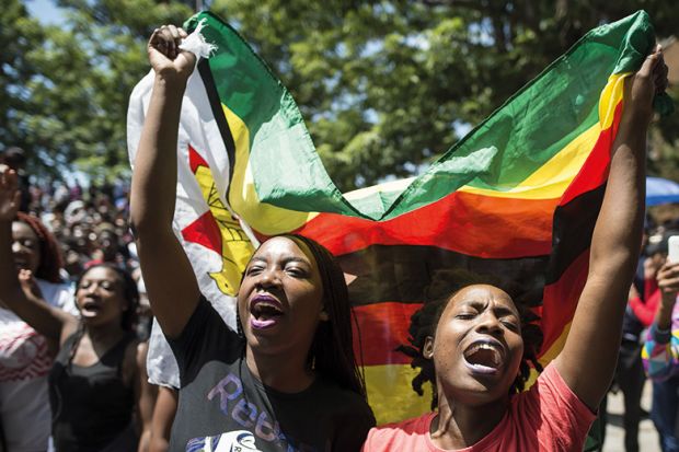 Women holding a flag of Zimbabwe in a demonstration at the University of Zimbabwe
