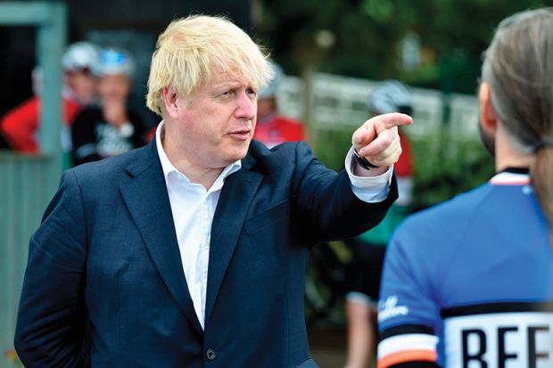 Britain's Prime Minister Boris Johnson (L) gestures as he talks to members of a local cycling club at the Canal Side Heritage Centre in Beeston, central England, on July 28, 2020