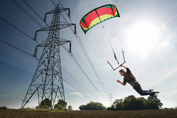 Man paragliding near power lines