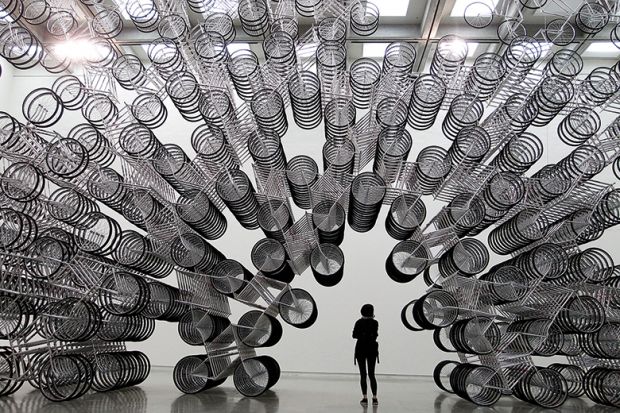 A woman looks at an art installation of bicycles in Taipei October 28, 2011