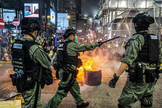 Police stand guard on a road to deter pro-democracy protesters from blocking roads in the Mong Kok district of Hong Kong on May 27, 2020, as the citys legislature debates over a law that bans insulting China's national anthem. 