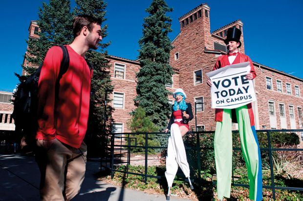 Person on stilts encourages students on the University of Colorado campus to vote
