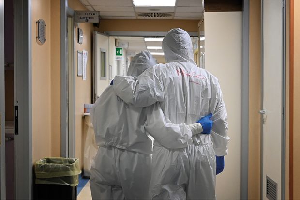Doctor and nurse at the end of their shift in a corridor of the intensive care unit, treating COVID-19 patients. Italy.