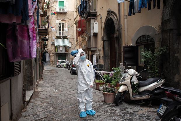A healthcare worker wearing a protective suit walks through the Quartieri Spagnoli (Spanish Quarters) to screen people for coronavirus (Covid-19) during the pandemic. Italy