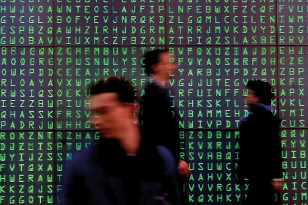 Visitors pass a giant Videoscreen with moving letters symbolising security codes at the computer- fair Cebit in Hanover