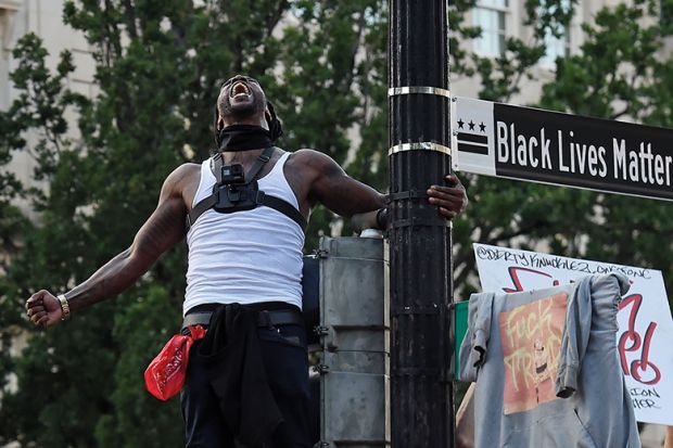 Man screams near a street sign that has been renamed 'Black Lives Matter Plaza' near the White House  during a demonstration against racism and police brutality, in Washing