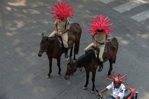 Police personnel wearing coronavirus-themed helmets ride on horses as they participate in a awareness campaign during a 21-day government-imposed nationwide lockdown as a preventive measure against the COVID-19 coronavirus. India
