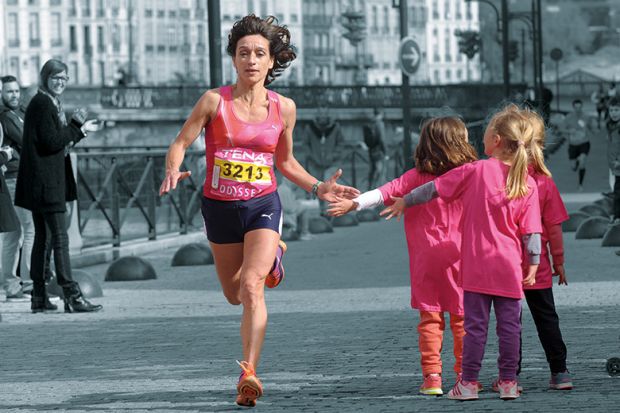 A female runner giving children a high five as she runs past.