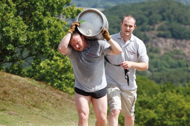 Tired man carrying beer barrel uphill