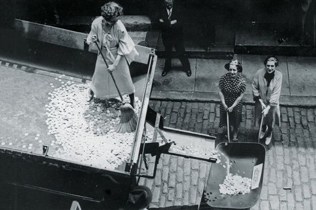 Woman sweeping coins into a wheelbarrow