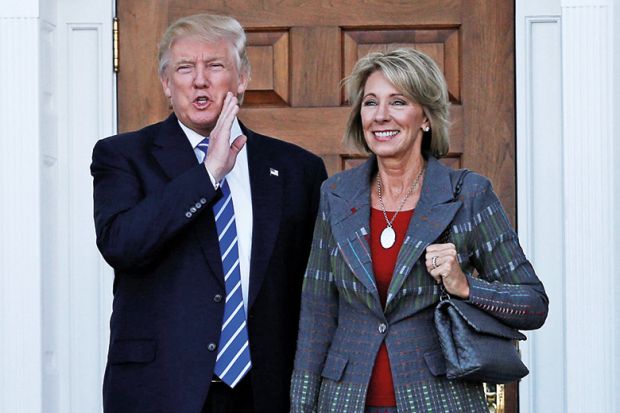 Donald Trump standing with Betsy DeVos