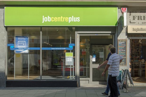 Two men walking past the Job Centre Plus government employment office in the centre of Weston-Super-Mare