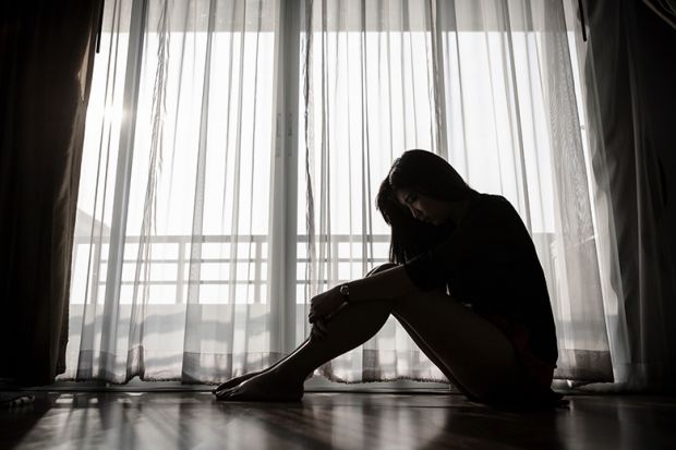 Unhappy young woman sitting alone