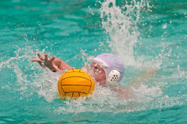 Water polo player swimming for the ball