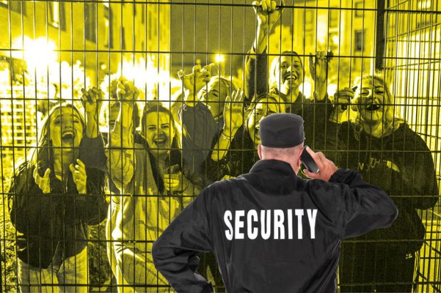 Security guard in front of fence with crowd smiling people behind