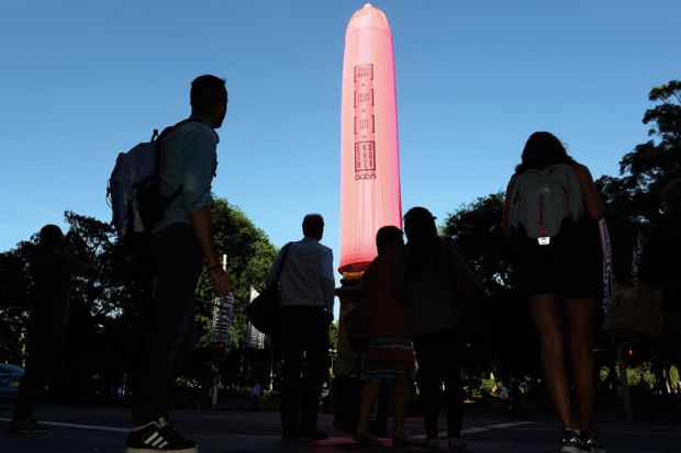 People look at a gaint condom over a heritage-listed obelisk at Hyde Park in Sydney to illustrate Concern over HIV cases among Australia’s international students