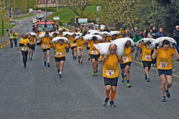 Competitors take part in the Mens Veterans Race at the annual World Coal Carrying Championships to illustrate PhDs for everyone will?not improve academia