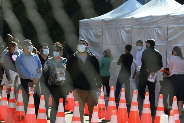 People wait in long lines for coronavius tests at a walk-up Covid-19 testing site