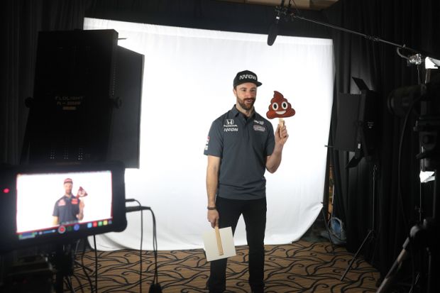 James Hinchcliffe holds a poop emoji while filming on a screen to illustrate Academics despair as ChatGPT-written essays swamp marking season