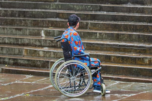 Man in wheelchair looking at steps to illustrate Two-thirds of disabled PhD students poorly supported, says study