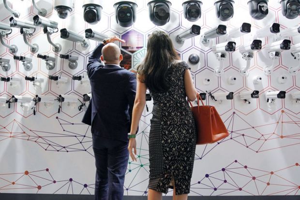 People look at surveillance cameras at the annual Huawei Connect event in Shanghai, China to illustrate Party strengthens control of Chinese university administration
