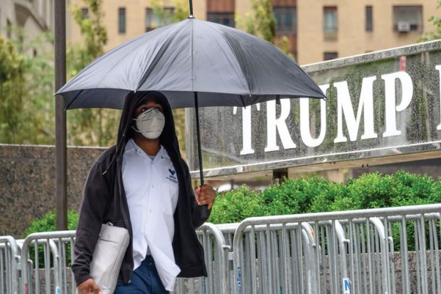 A person wears a protective face mask outside Trump International Hotel & Tower New York 