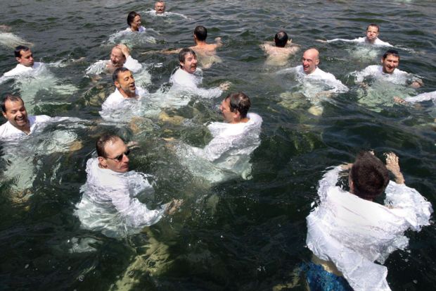 Group swim in their white lab coats in a lake to illustrate ‘We know what the problems are’: UK PhD consultation ‘vague’