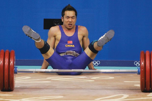 Weightlifter representing China drops the weight and falls on floor as a metaphor that Chinese excellence drive ‘may make universities weaker’