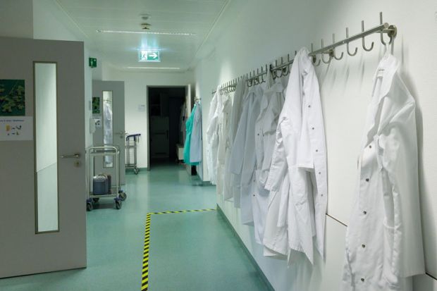 Lab coats hang in a corridor to illustrate Italian postdoctoral reforms ‘could lead to elimination of 5,000 jobs