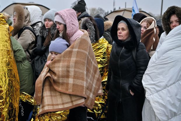 Refugees wrapped in blankets stand in line in the cold as they wait to be transferred to a train station after crossing the Ukrainian border to illustrate Five universities join forces to offer ‘wrap-around’ support to refugees