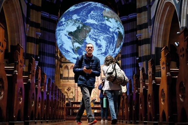 People look at a giant globe of the world measuring seven metres in diameter at St Paul's Cathedral in Melbourne 