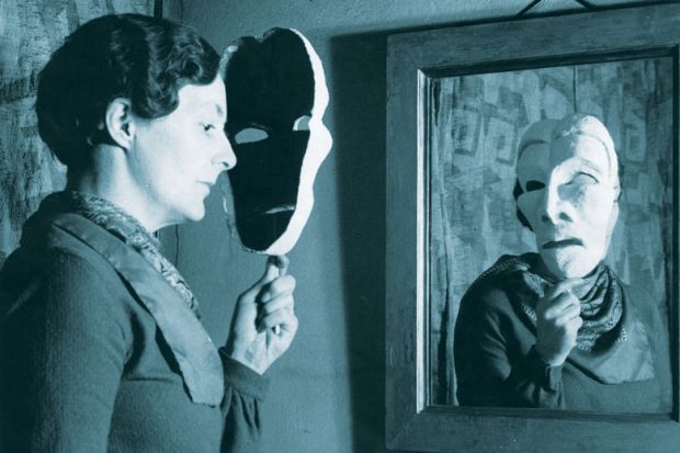 woman looking in mirror holding a mask as a metaphor for Academic conclusions differ wildly even on same data, study finds