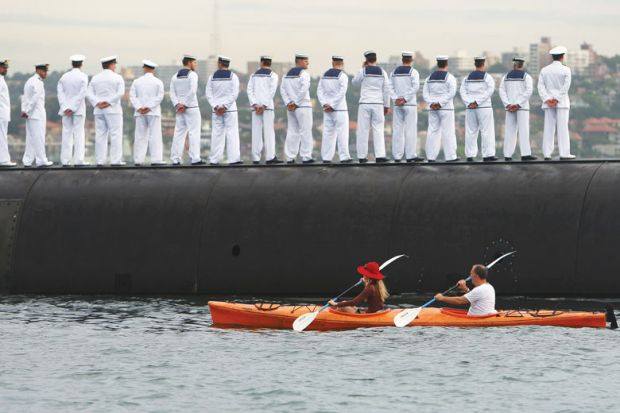 Sailors stand in line with a boat going behind them as a metaphor for Defence research ‘antidote’ to Covid’s lost billions: thinktank