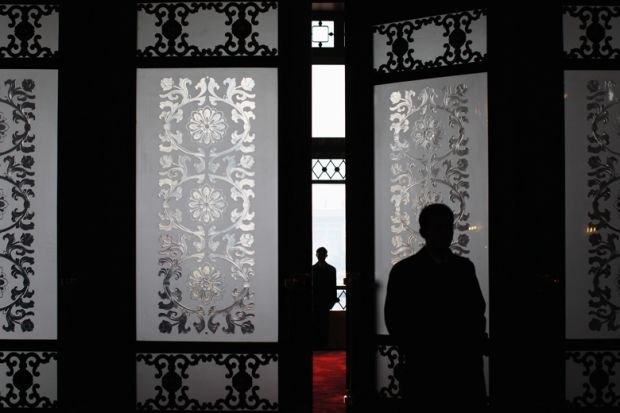 A security officer stands guard at the main entrance of the Great Hall of the People in Beijing, China to illustrate fears grow over missing academics