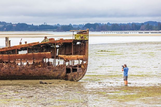 Tourist photographs the Janie Sedan Shipwreck, New Zealand, Oceania, South Island to illustrate New Zealand funding model ‘not fit for purpose’