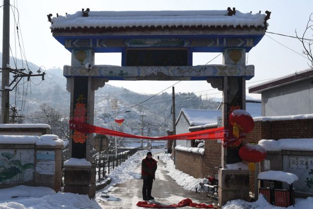 Residents stand at the entrance to Beicibeiyu village, blocked off to illustrate Experts doubtful as China launches new open access push