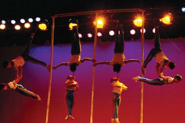 Acrobats linking arms in the air