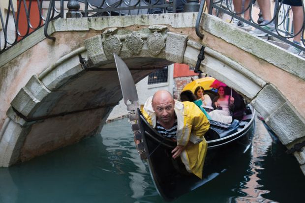  A gondolier crouches down under a bridge as a metaphor for long-running campaign by foreign university staff in Italy to gain equal pay and conditions to their local counterparts