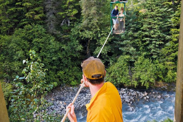  Man pulling hikers across the hand tram at Winner Creek to illustrate US research funding emerges as election battleground